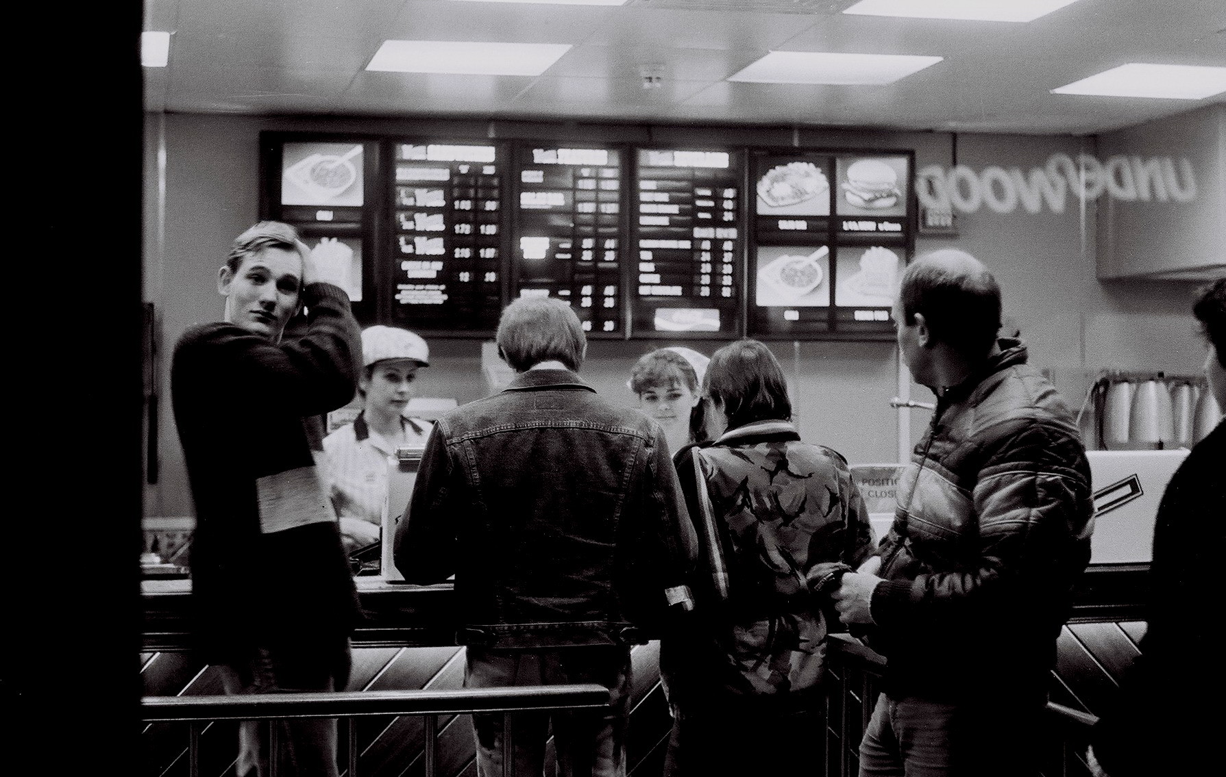 Friends photographed thru the window of Wendy burgers on upper Regent Street, Lo Group of teenagers in Wendy’s fast food outlet, London, UK, 1984 by Mark Charnock