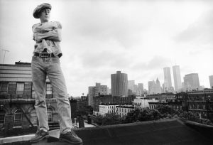 Man stood on roof top wearing denims and cap Dill name belt New York US 1980's