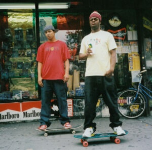 Two teenagers on their skateboards outside some shops, USA, 1990s